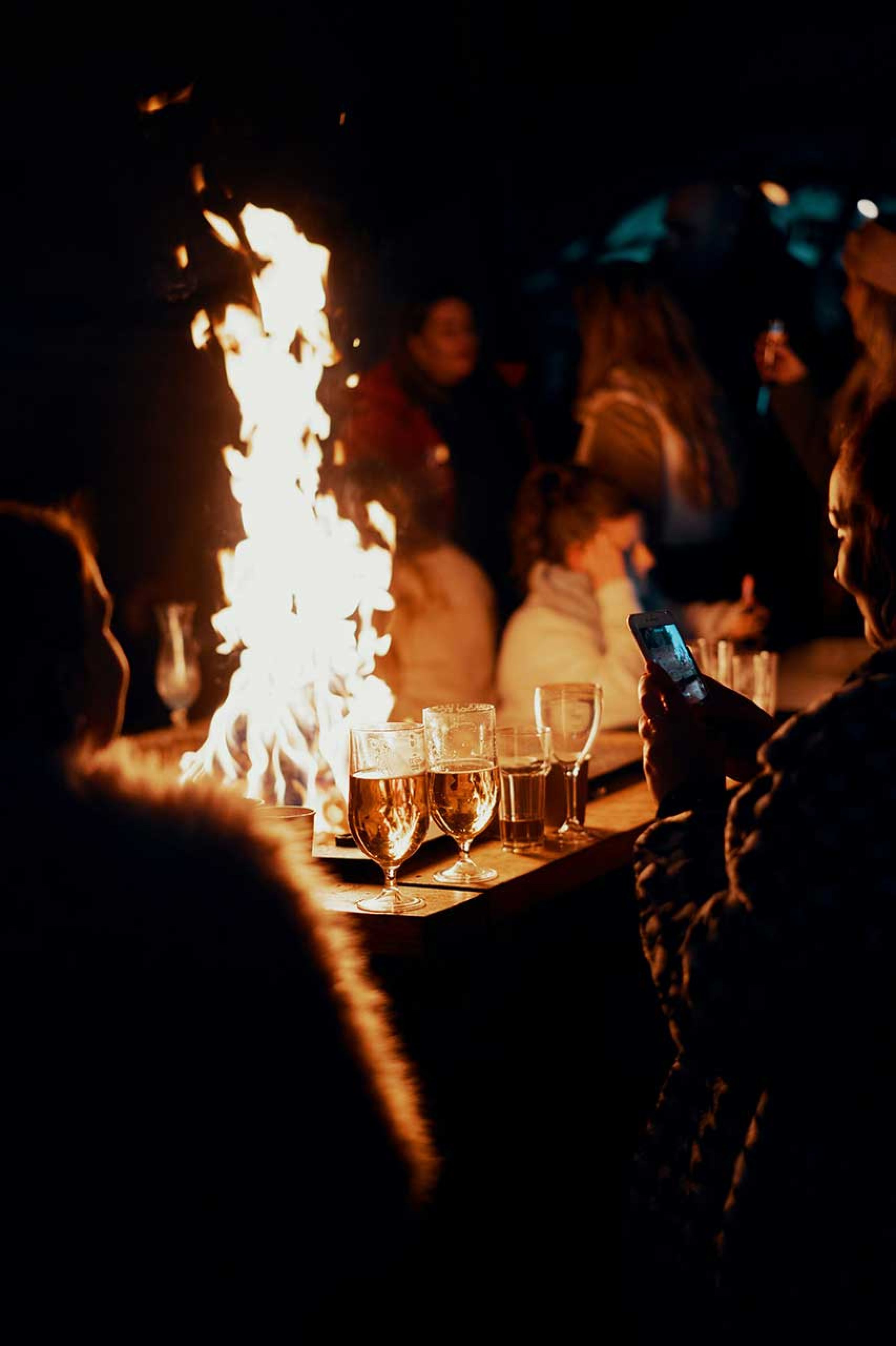 Menschen sitzen an einem Tischfeuer